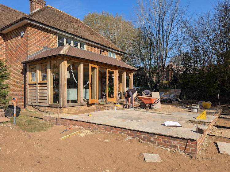 Sandstone terrace for family dining with flowerbeds positioned to frame views