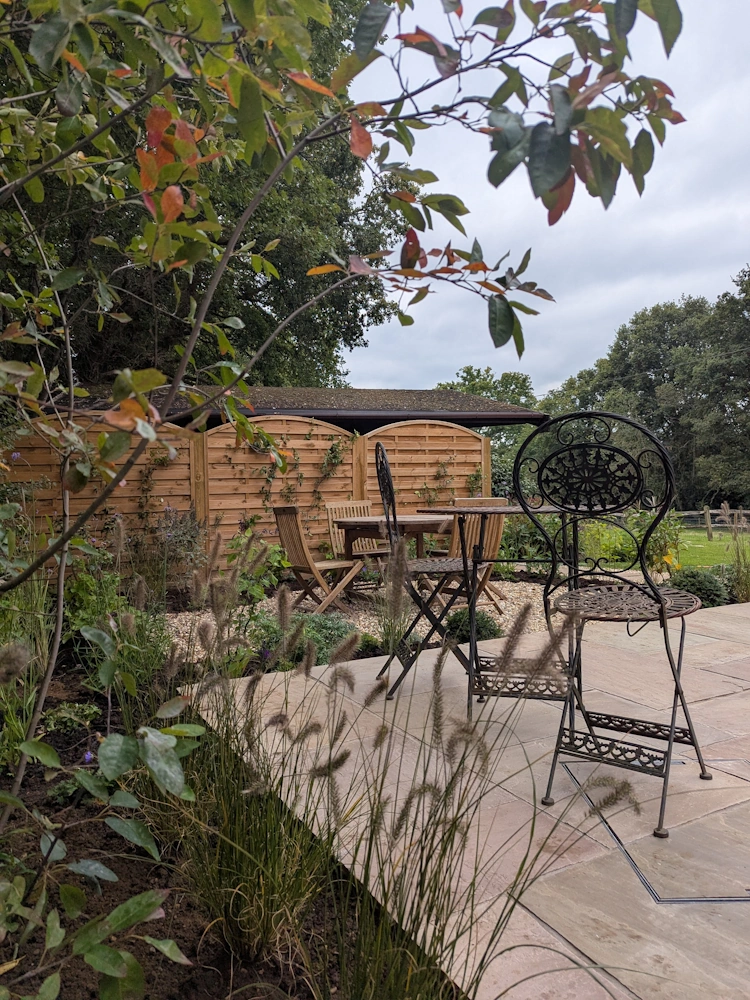 Evergreen and topiary pieces providing year-round structure and cottage garden character