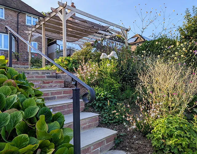 Garden on slope with pergola and patios
